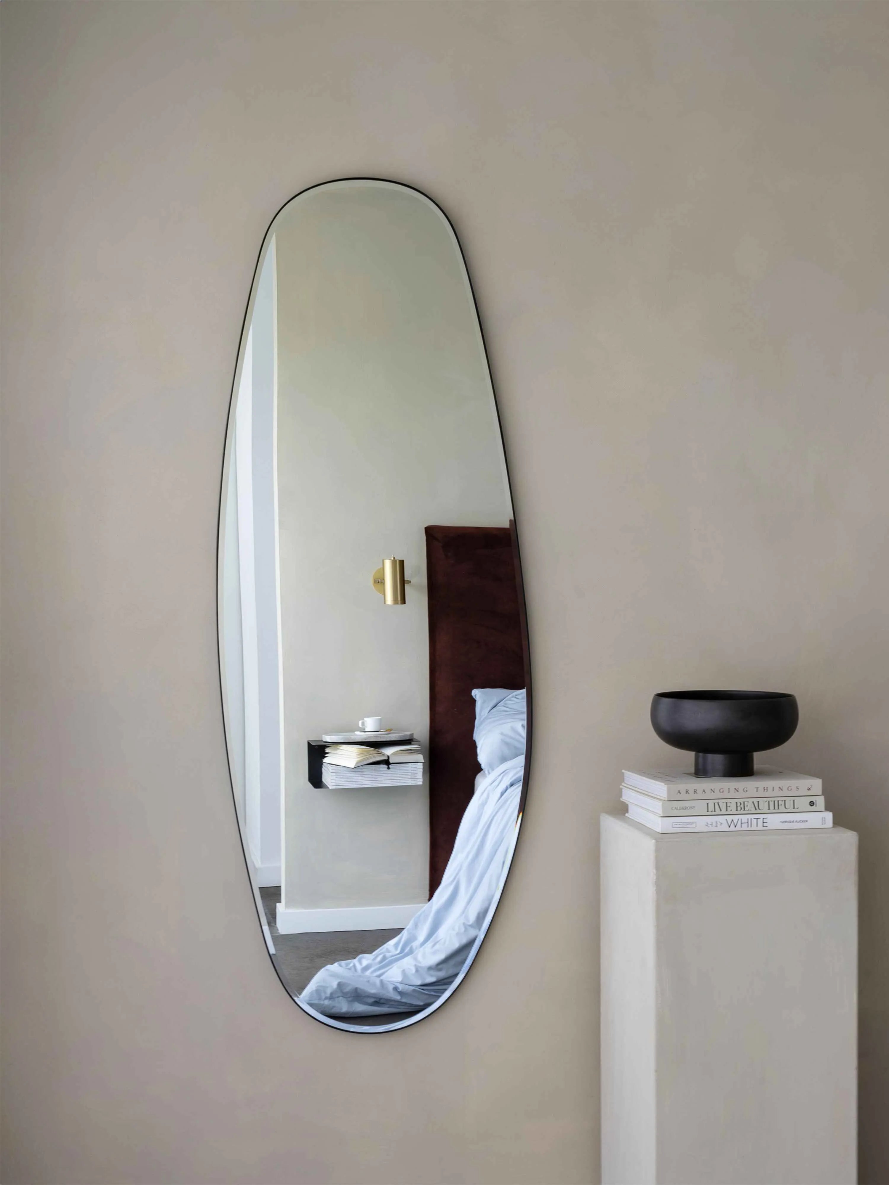 Opal Mirror showing reflection of bedside with standing bookstand next to it