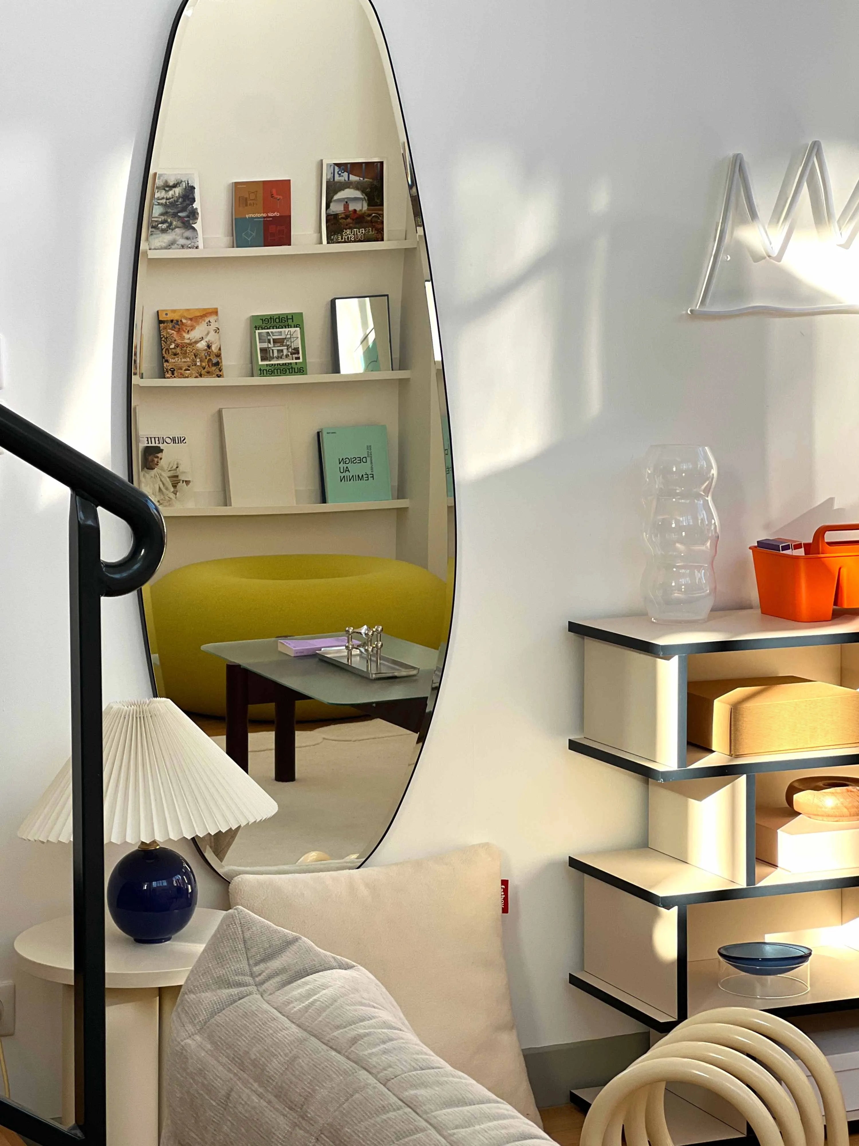 Opal Mirror Large in aesthetic living room reflecting some books and a round sofa