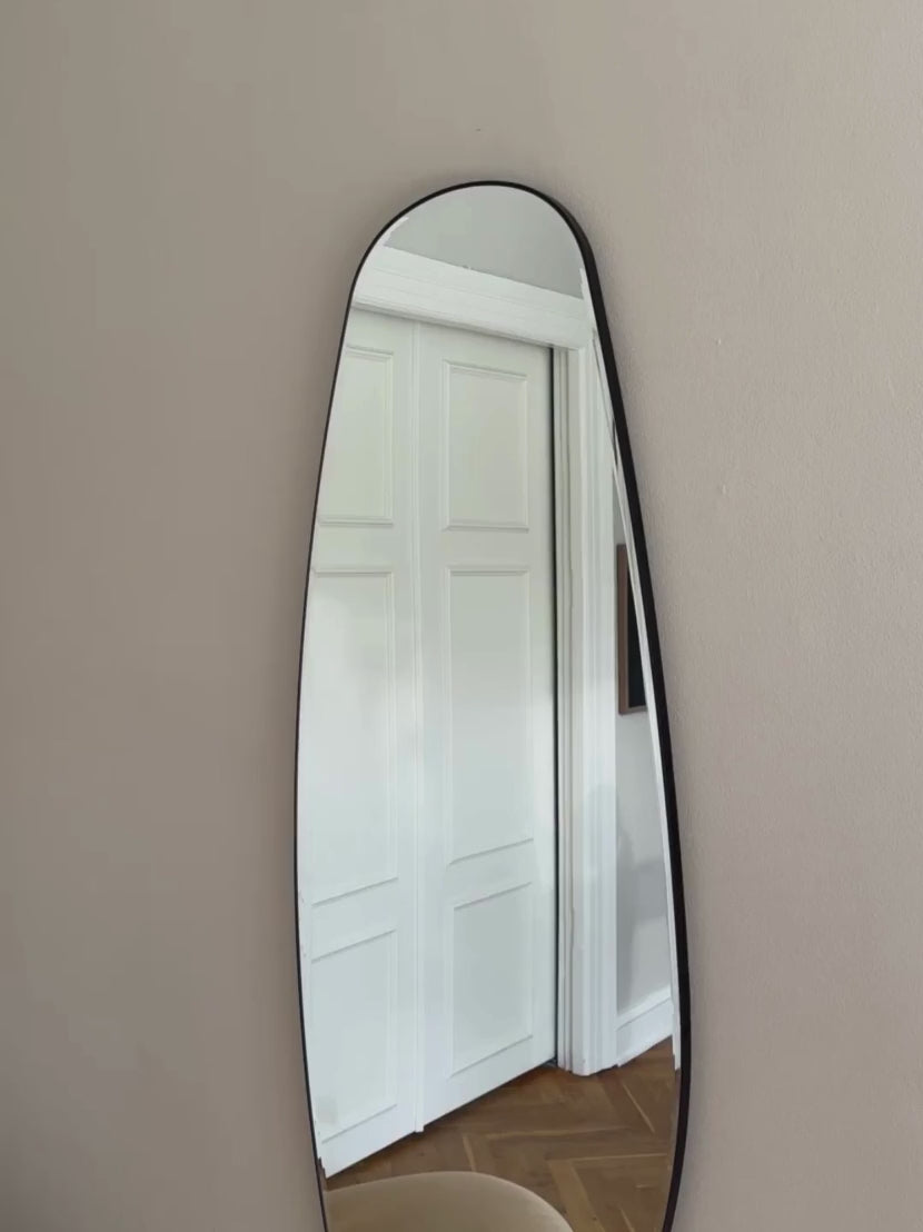 Opal Mirror Large video showing a minimalist living room in the reflection