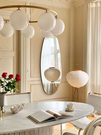 Opal Mirror Large in living room with standing pendant light and marble table